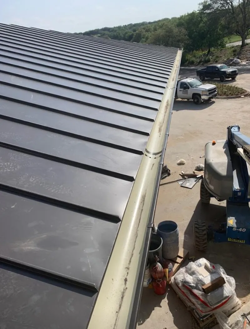 Standing seam panel and gutter detail on a metal roofing jobsite in Ellenton